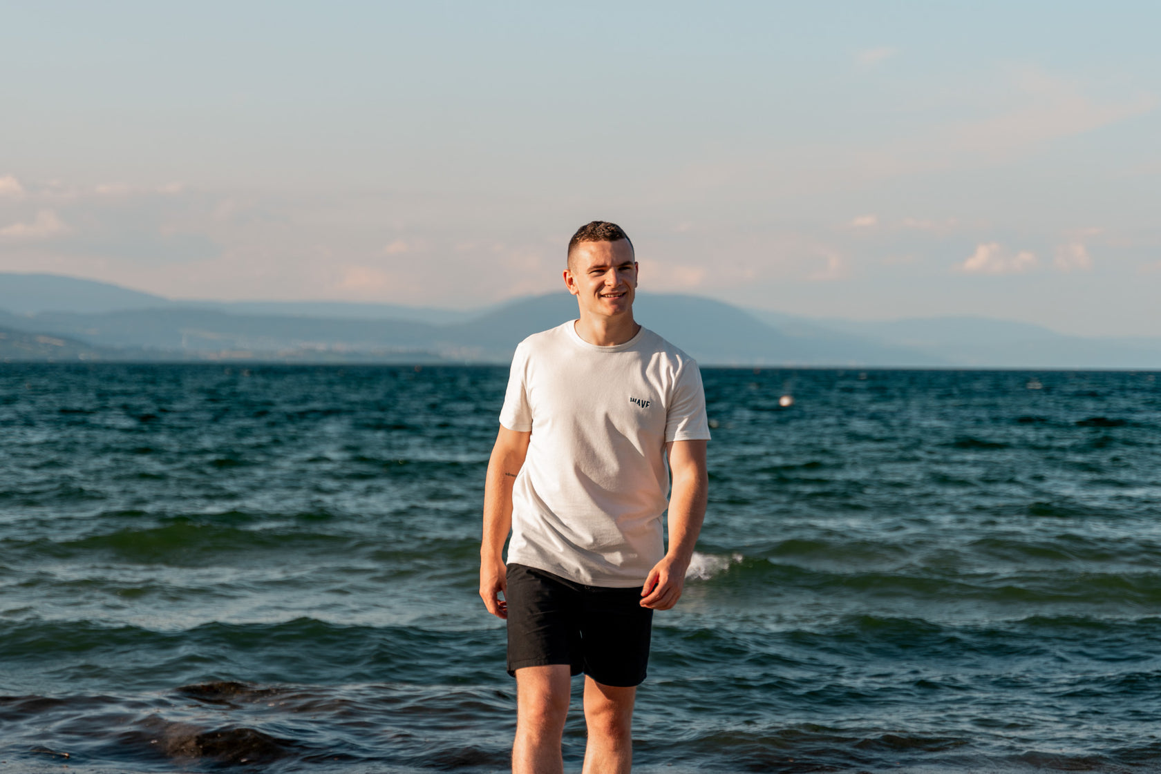 Homme avec un t-shirt écologique suisse au bord de la mer 