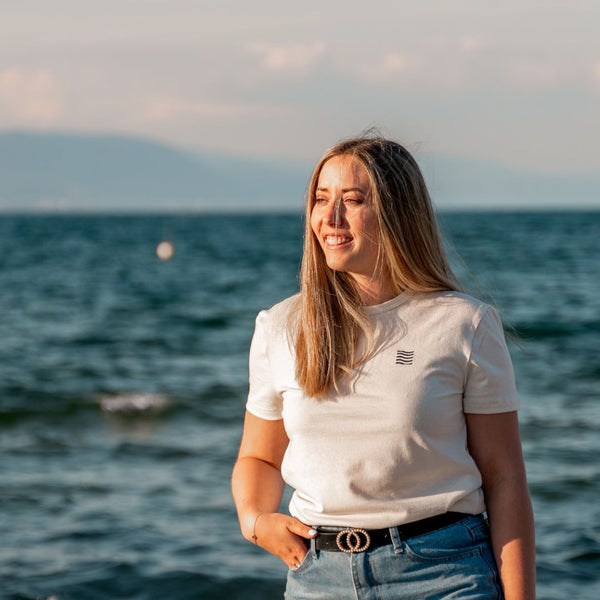 Femme avec un t-shirt écologique suisse au bord de la mer 