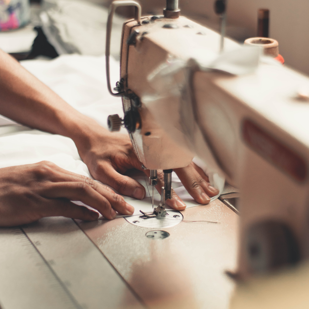 personne entrain de coudre sur un tissu avec une machine à coudre