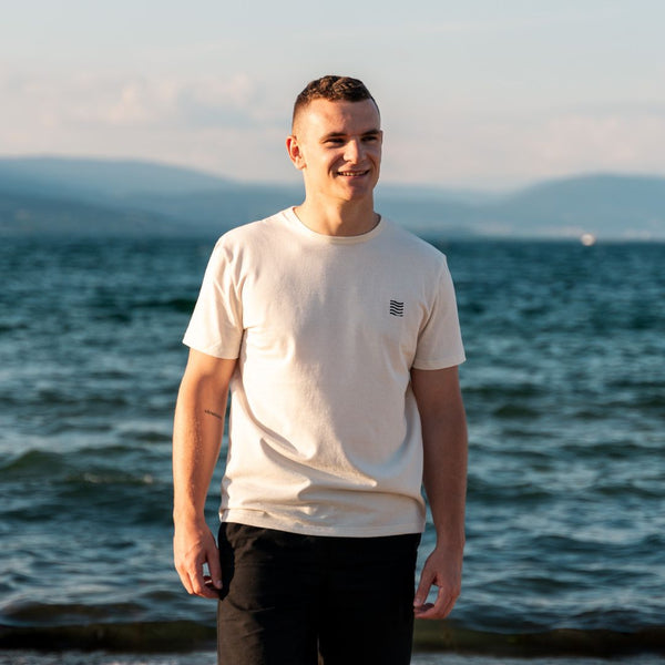 Homme avec un t-shirt écologique suisse au bord de la mer 