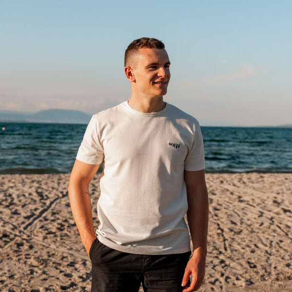 Homme avec un t-shirt écologique suisse au bord de la mer 