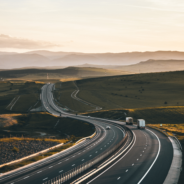 Autoroute avec des véhicules au couché de soleil